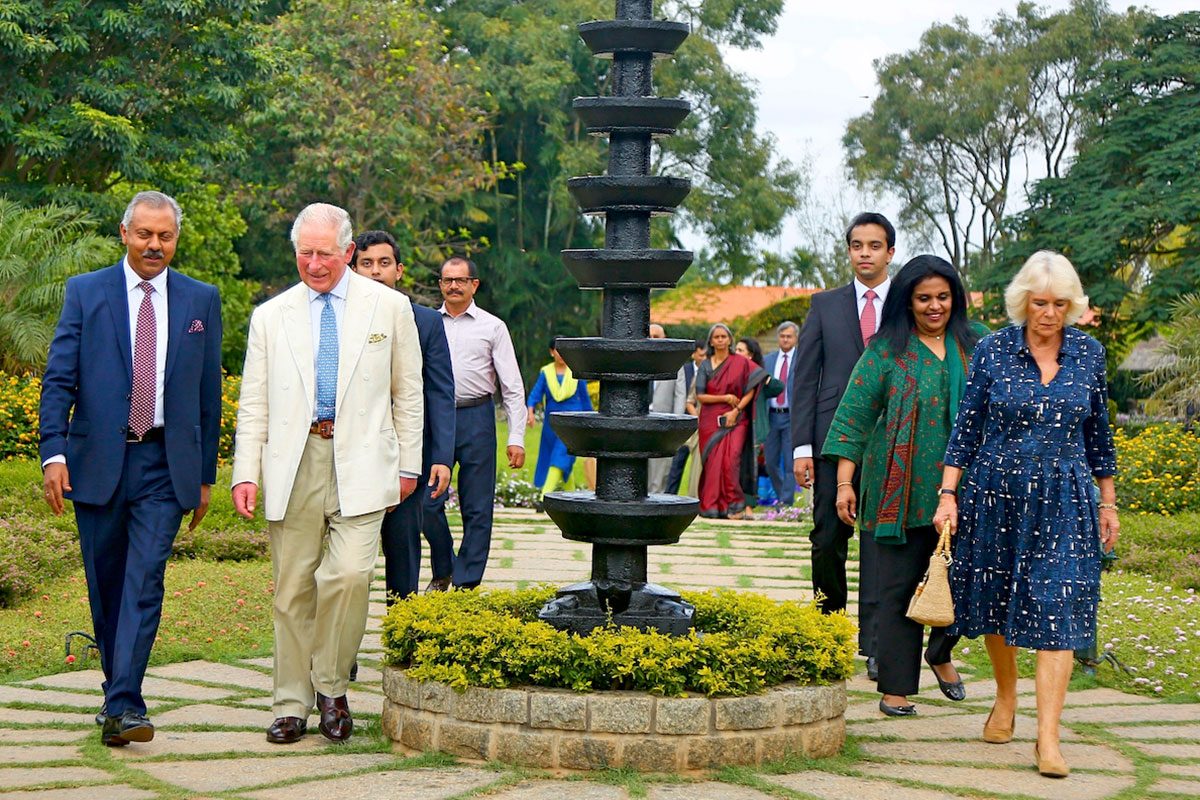The Then Prince Of Wales And Duchess Of Cornwall Walking Through The Gardens At Soukya With Founder Dr. Isaac Mathai